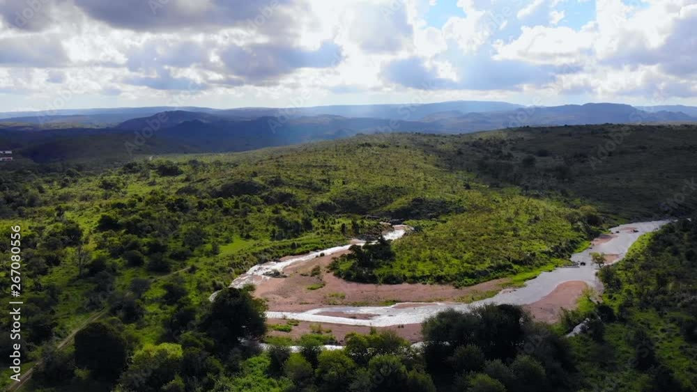 Aerial shot of a winding river, between green hills and fields, on a sunny day, away point of view. Aerial shot of a winding river, between green hills and fields, on a sunny day, away point of view.