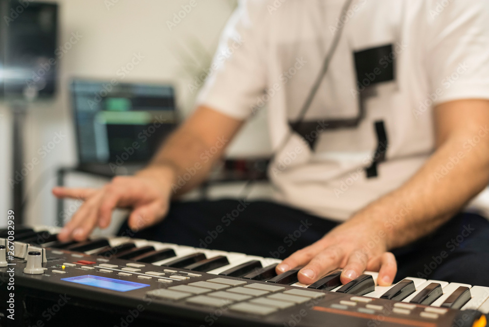 Close up of musician playing midi keyboard in home music studio. Close up of musician playing midi keyboard in home music studio.