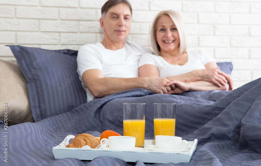 Romantic happy couple having breakfast in bed