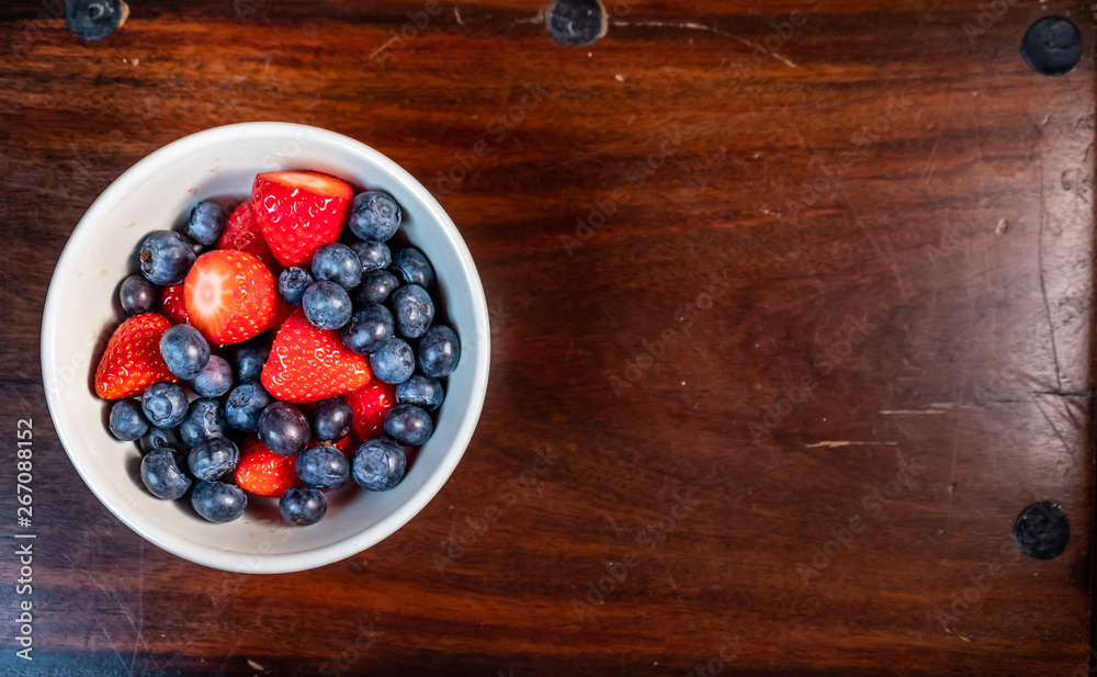 Strawberries and blueberries in white bowl ready to eat Strawberries and blueberries in white bowl ready to eat