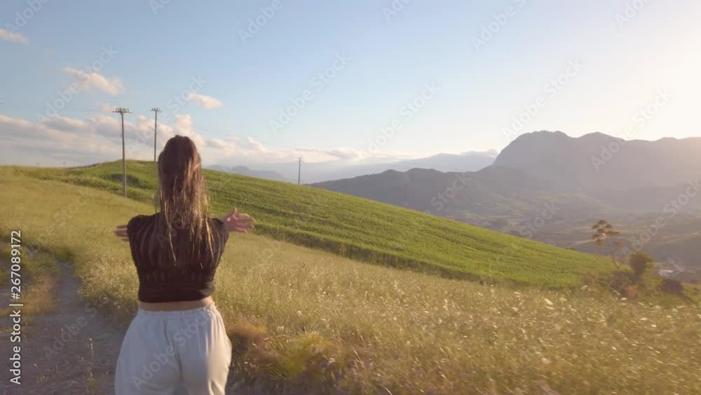 Ragazza con tuta grigia e maglia nera balla a ritmo di musica in mezzo a una strada in campagna tra la natura. Tramonto del sole sullo sfondo. Ragazza con tuta grigia e maglia nera balla a ritmo di musica in mezzo a una strada in campagna tra la natura. Tramonto del sole sullo sfondo.