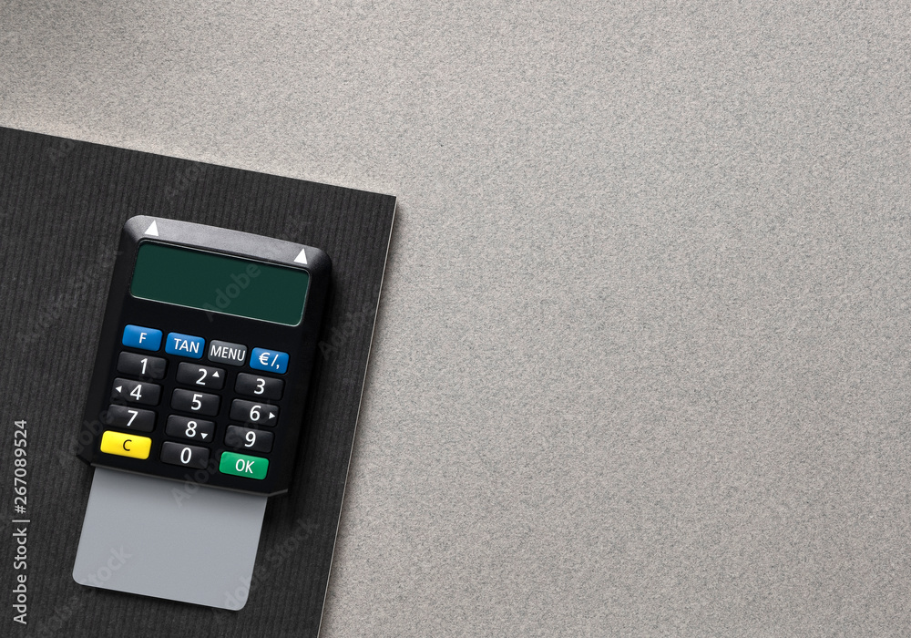 TAN Generator with empty debit card- credit card on gray office ...