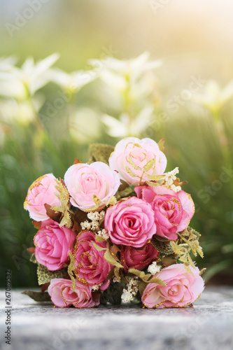 Pink Roses bouquet on concrete floor in the garden with sunlight and green natural background. Valentine Day for love and celebration Concept.