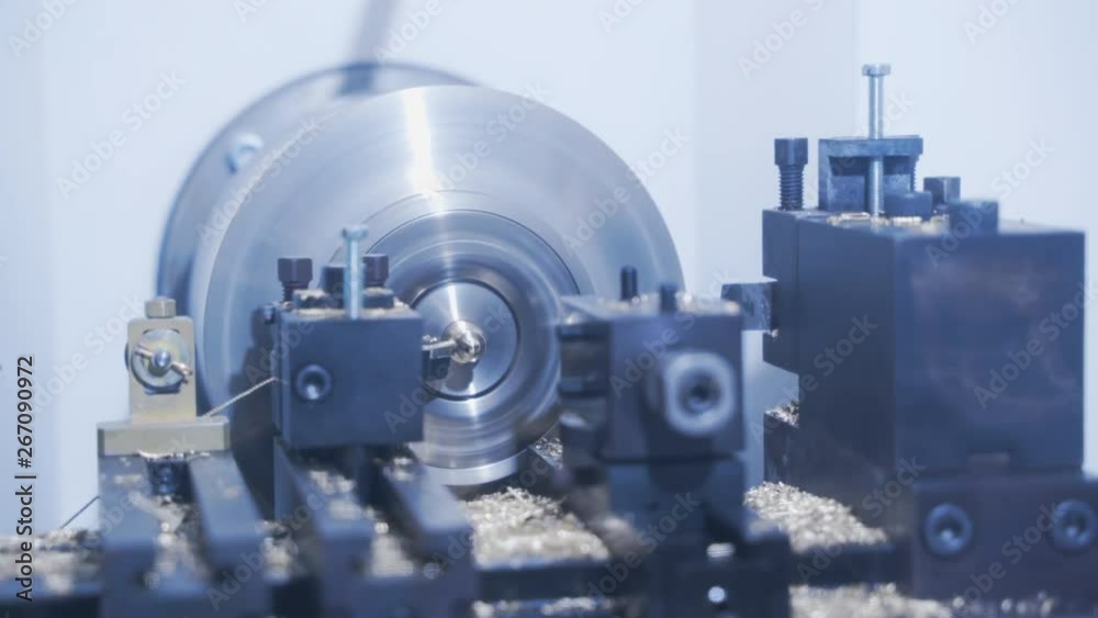 Machining of metallic product close up. Computer control of high tech manufacture for accuracy of construction. CNC milling machine makes some steel part on a factory. Shavings from motion of drill Machining of metallic product close up. Computer control of high tech manufacture for accuracy of construction. CNC milling machine makes some steel part on a factory. Shavings from motion of drill