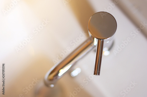 Fotografija Closed up Silver Steel Basin Faucet with sunlight on top view in the bathroom