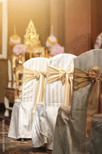 Beautiful chairs decoration with ribbon in wedding event hall, selective focus.