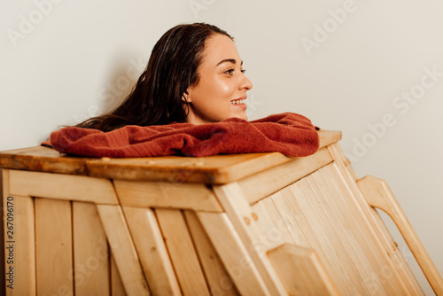 smiling woman taking steam bath in spa center photo