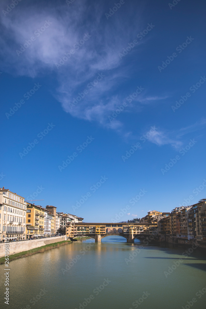 Fototapeta premium Sunny view on the Arno River and Ponte Vecchio in Florence, Italy