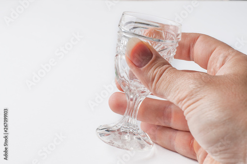 A glass holding a hand isolated on a white background.