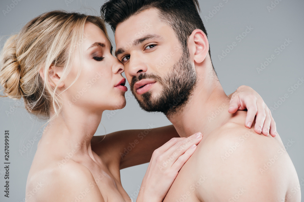 Fototapeta premium beautiful nude young woman hugging handsome shirtless man on grey