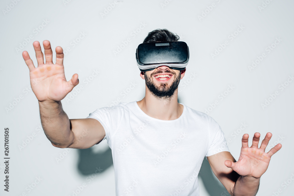 cheerful bearded man wearing virtual reality headset while gesturing on white cheerful bearded man wearing virtual reality headset while gesturing on white