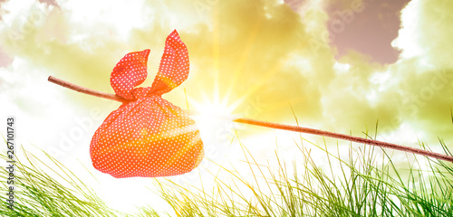 Rotes Wanderbündel am Stock in Landschaft