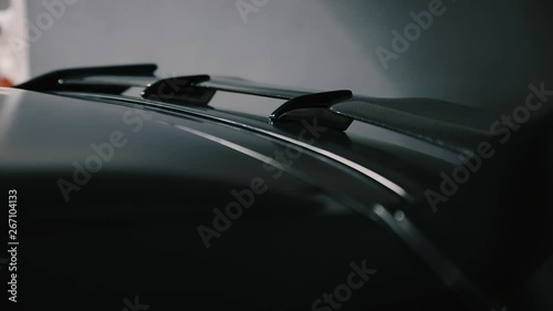 black carbon spoiler on the black matt tuning car closeup,