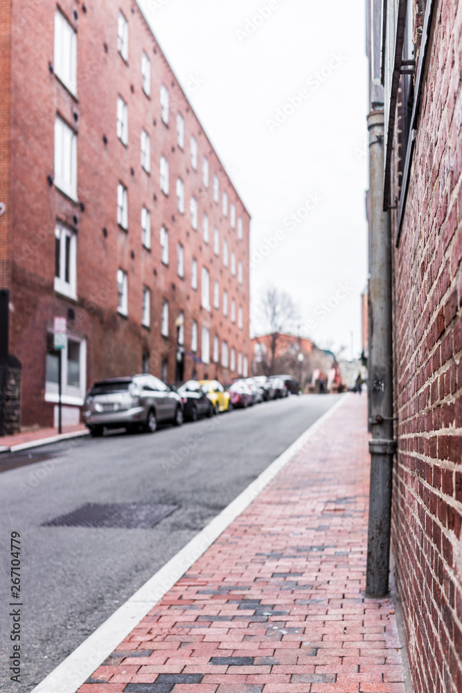 Brick alley in Georgetown, Washington DC with bokeh blurred background of parked cars