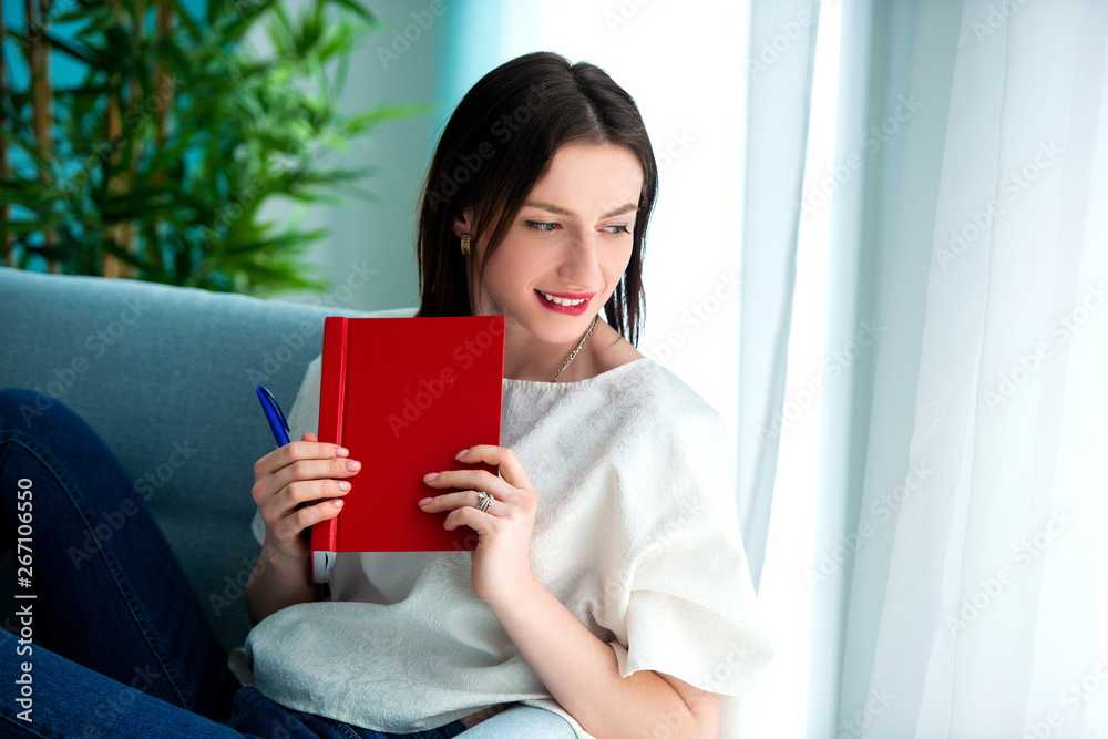 girl with a red note book at home girl with a red note book at home