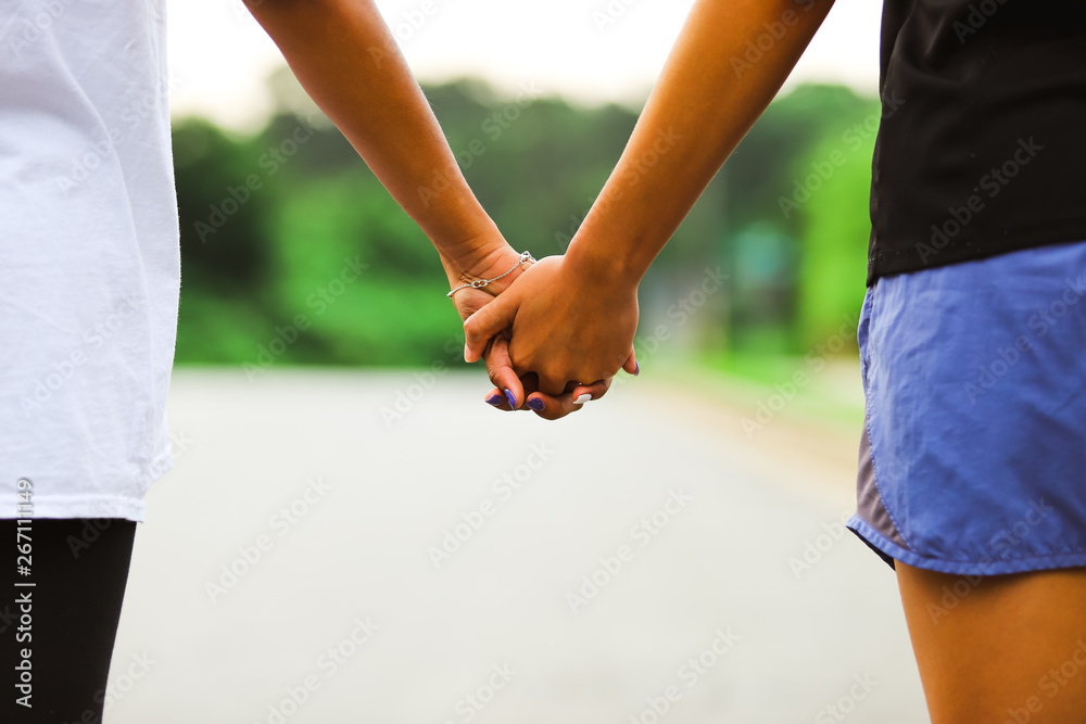 Sisters holding hands on blurred background Sisters holding hands on blurred background