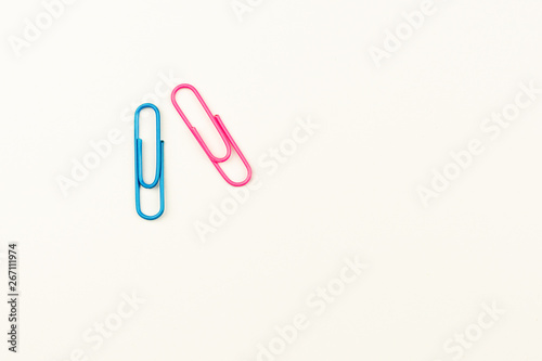 blue and pink paper clips on white background. - top view.