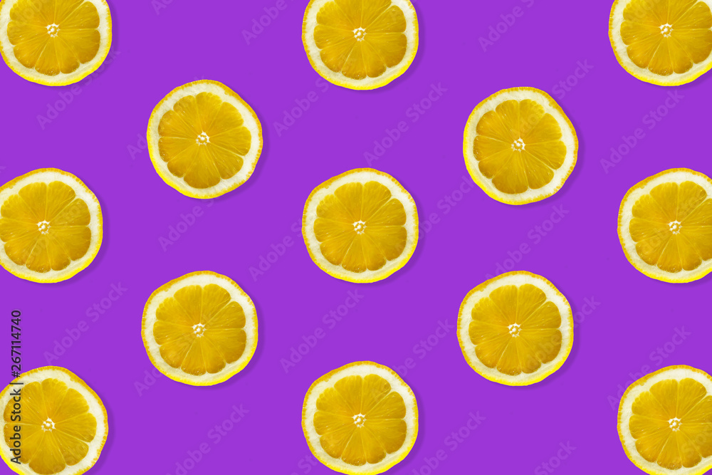 Creative pattern made of lemon. top view of fruit fresh limes slices on purple colorful background. 
