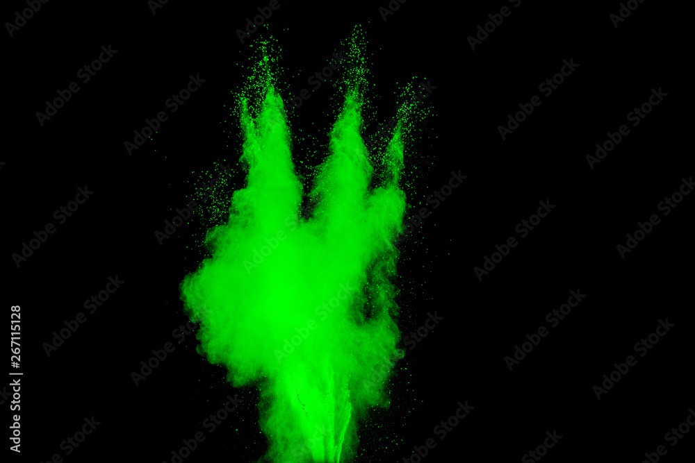 Abstract green powder explosion on  black background. Abstract green dust splattered on black background. Freeze motion of green powder splash.