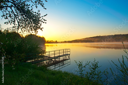 beautiful sunrise over a calm lake with a blue clear sky