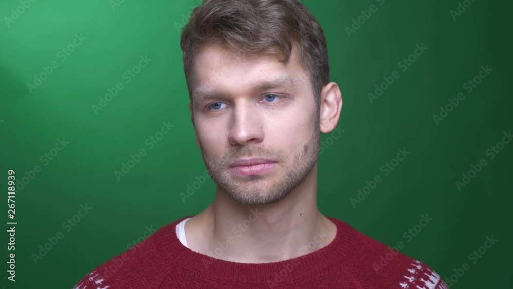 Brunette businessman in sweater dancing weirdly on green background. Brunette businessman in sweater dancing weirdly on green background.