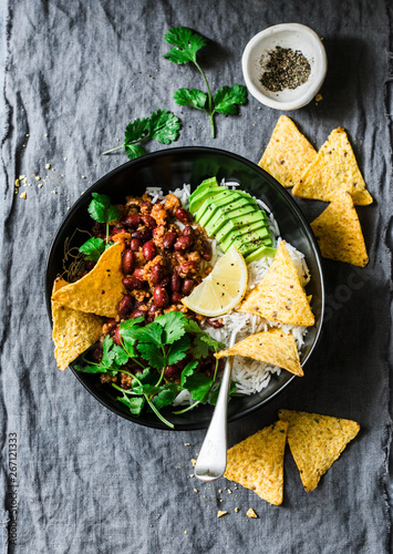 Rice with spicy beans beef minced with corn chips on a gray background, top view. Mexican style food