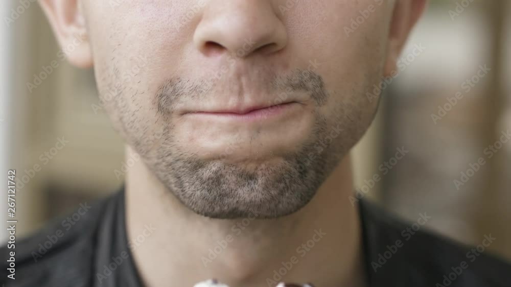 Handsome young man eating a chocolate ice-cream Handsome young man eating a chocolate ice-cream