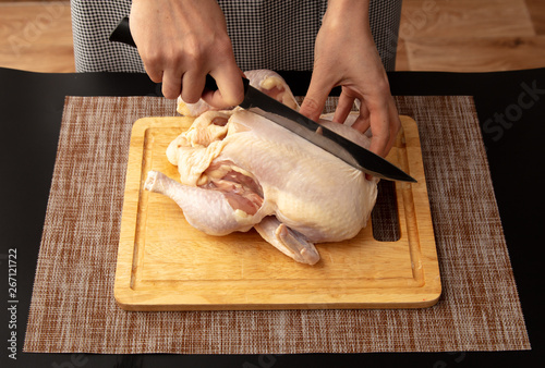 Cutting chicken carcass on a board on a black background