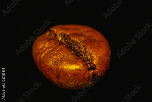 Coffee grain on black background magnified, closeup.