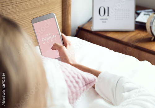 Person Using Smartphone on a Bed Mockup