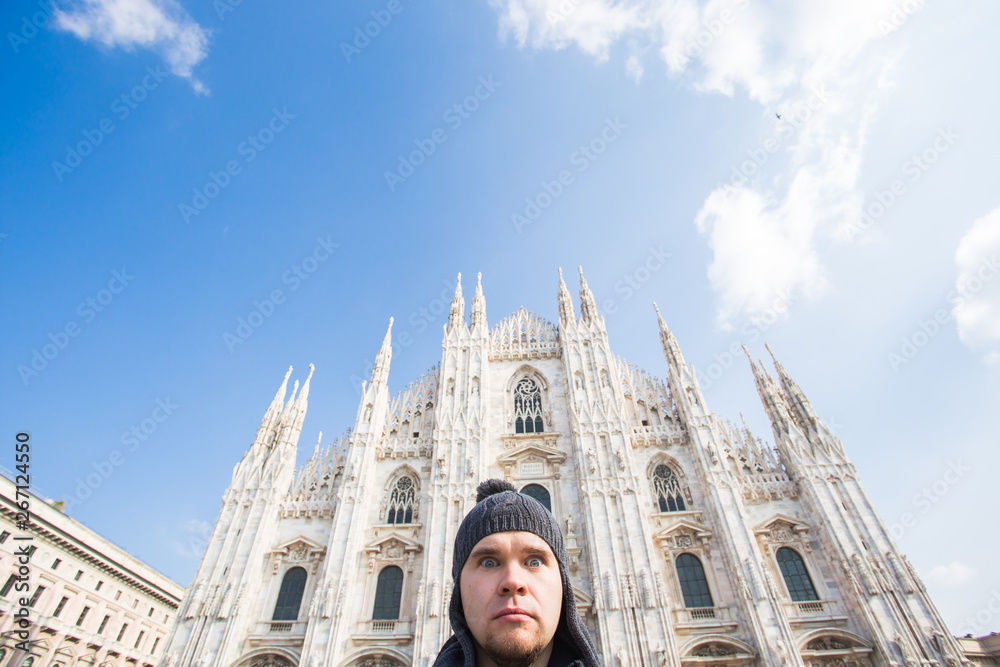 Winter travel, vacations and holidas concept - Young funny man taking selfie near Milan Cathedral Duomo di Milano, Italy.