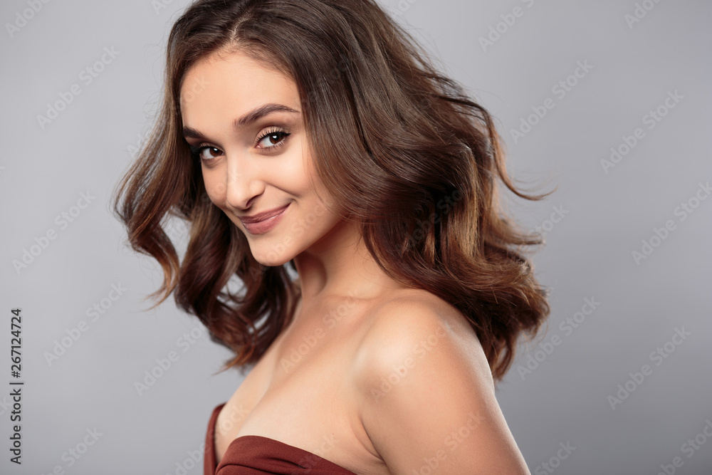 Brunette girl with healthy curly hair and natural make up . Beautiful model woman with wavy hairstyle .Care and beauty Brunette girl with healthy curly hair and natural make up . Beautiful model woman with wavy hairstyle .Care and beauty