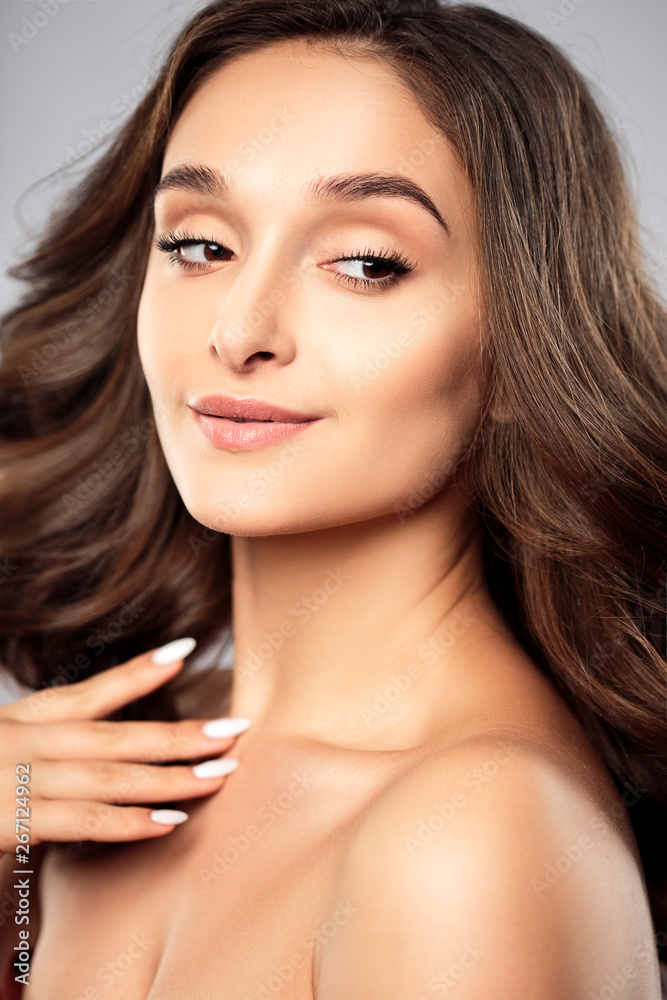 Brunette girl with healthy curly hair and natural make up . Beautiful model woman with wavy hairstyle .Care and beauty Brunette girl with healthy curly hair and natural make up . Beautiful model woman with wavy hairstyle .Care and beauty