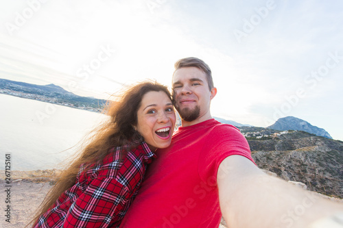Travel, vacation and holiday concept - Beautiful couple having fun, taking selfie over beautiful landscape