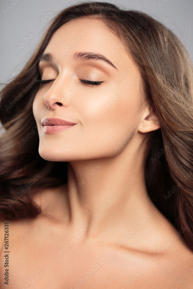 Brunette girl with healthy curly hair and natural make up . Beautiful model woman with wavy hairstyle .Care and beauty Brunette girl with healthy curly hair and natural make up . Beautiful model woman with wavy hairstyle .Care and beauty