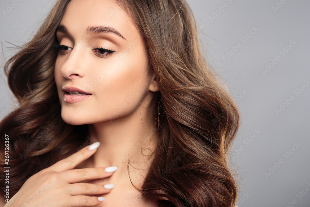 Brunette girl with healthy curly hair and natural make up . Beautiful model woman with wavy hairstyle .Care and beauty Brunette girl with healthy curly hair and natural make up . Beautiful model woman with wavy hairstyle .Care and beauty