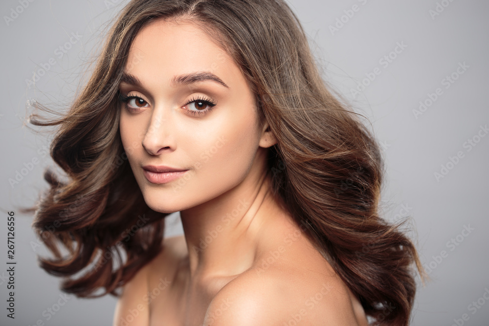 Brunette girl with healthy curly hair and natural make up . Beautiful model woman with wavy hairstyle .Care and beauty Brunette girl with healthy curly hair and natural make up . Beautiful model woman with wavy hairstyle .Care and beauty