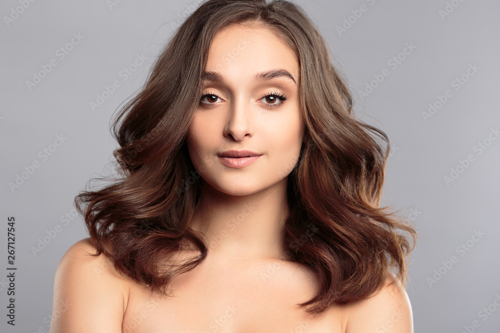 Brunette girl with healthy curly hair and natural make up . Beautiful model woman with wavy hairstyle .Care and beauty Brunette girl with healthy curly hair and natural make up . Beautiful model woman with wavy hairstyle .Care and beauty
