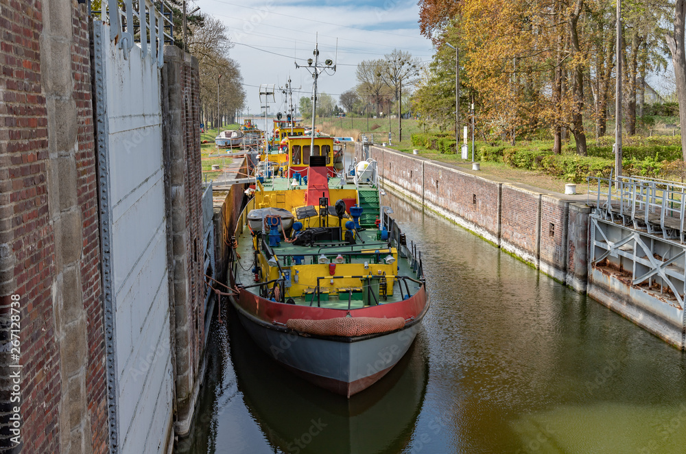 Sluice, water gate with colorful tugboats parked along the berth in Sobieszewo in Poland.