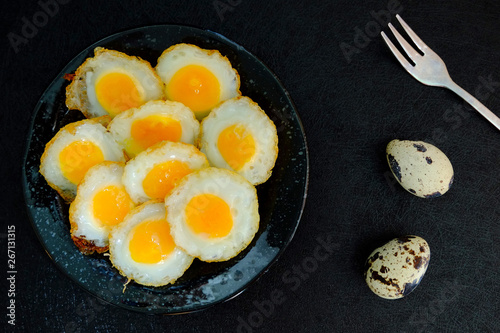 Fried quail egg on black background