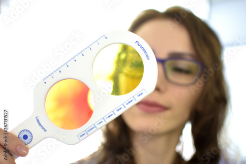 pretty young woman optometrist ophthalmologist optician performs a color blindness test, low depth of field