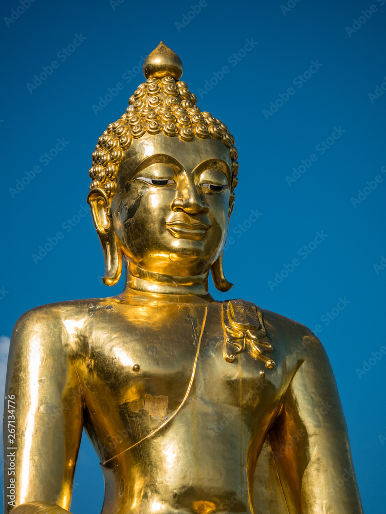 Big golden Buddha in blue sky