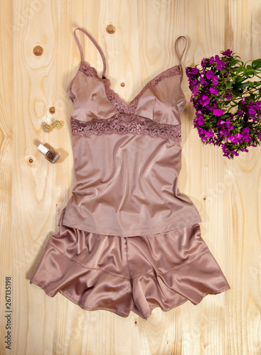Fényképezés top view of rose colored babydoll on wooden background