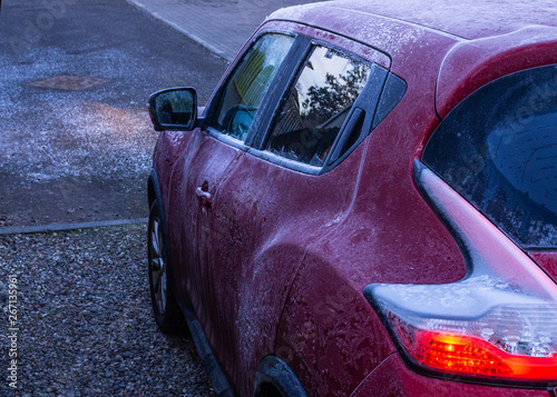 Purple car covered in frost on a very cold winter morning
