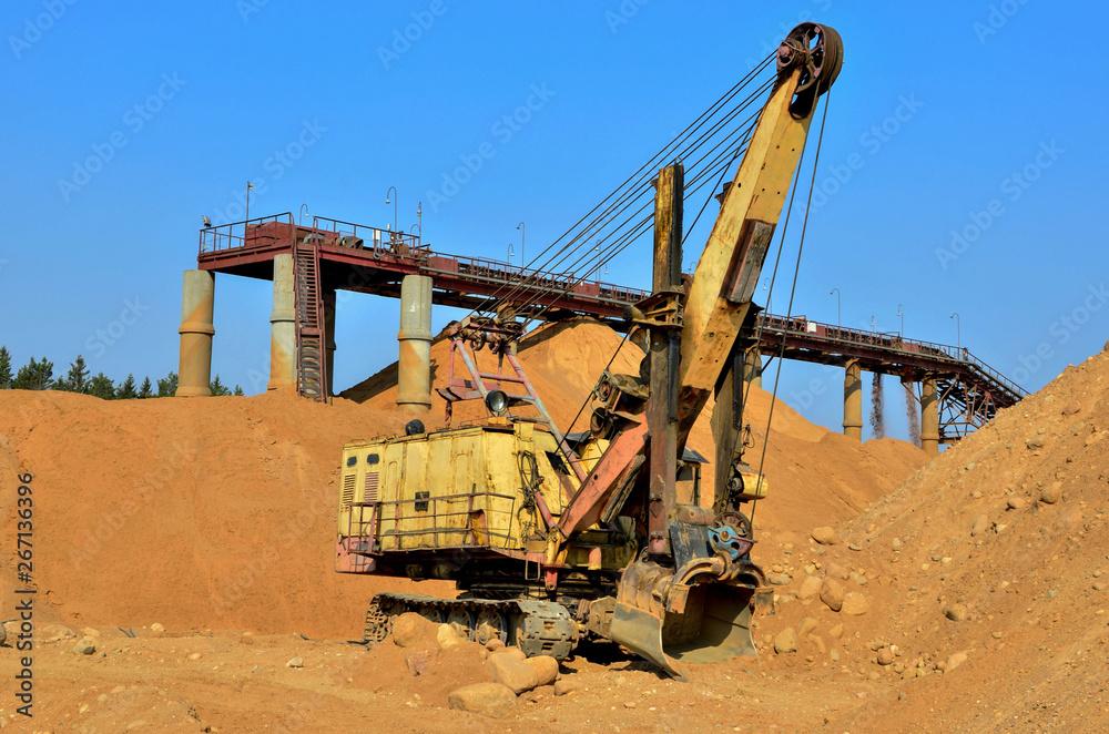 Large excavator in a quarry for the extraction of sand, gravel, rubble, quartz and other minerals Large excavator in a quarry for the extraction of sand, gravel, rubble, quartz and other minerals