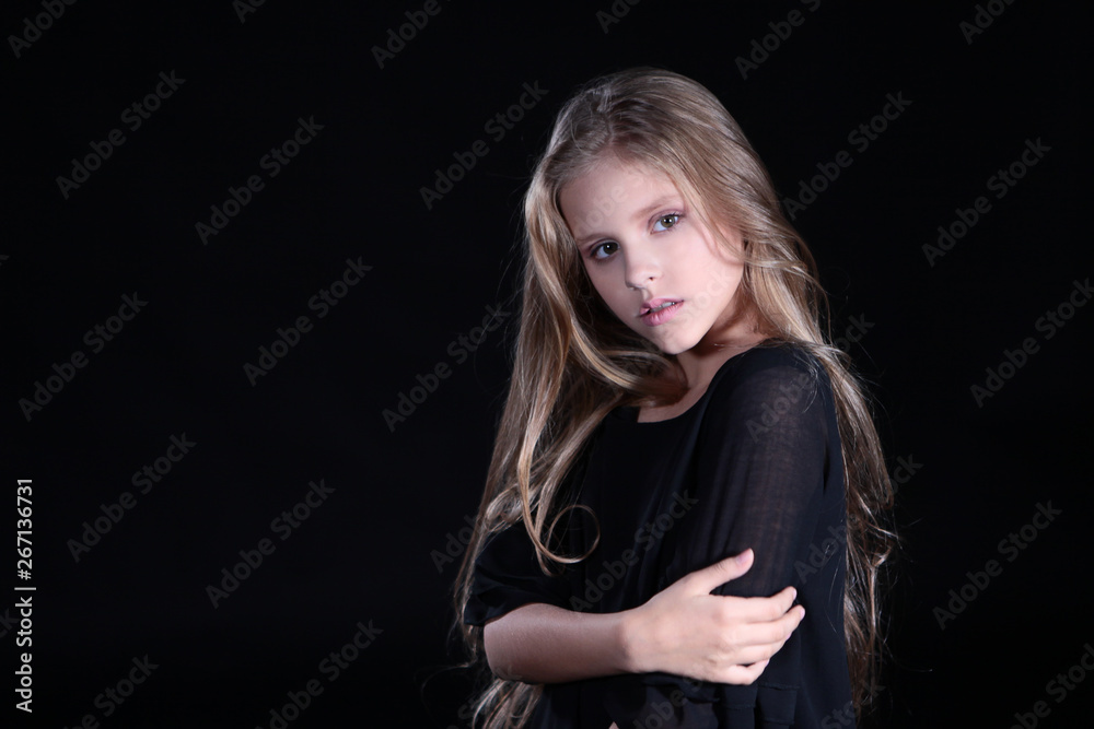 Portrait of a blonde girl with long hair on a black background. Emotional portrait.The girl shows different emotions on the face. Plays with long hair. Portrait of a blonde girl with long hair on a black background. Emotional portrait.The girl shows different emotions on the face. Plays with long hair.