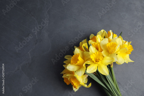 Bouquet of daffodils on dark background, top view with space for text. Fresh spring flowers photo