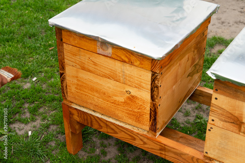 Painting new bee hives. A visible hand painting beehives. Preparation for the beekeeping season. Developing an apiary.