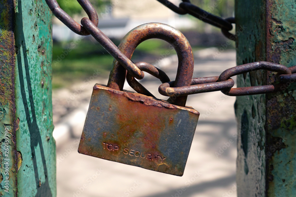 Rusty padlock on rusty chain.