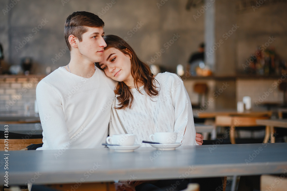 Pretty couple sitting in a cafe. Man and woman drinking a tea
